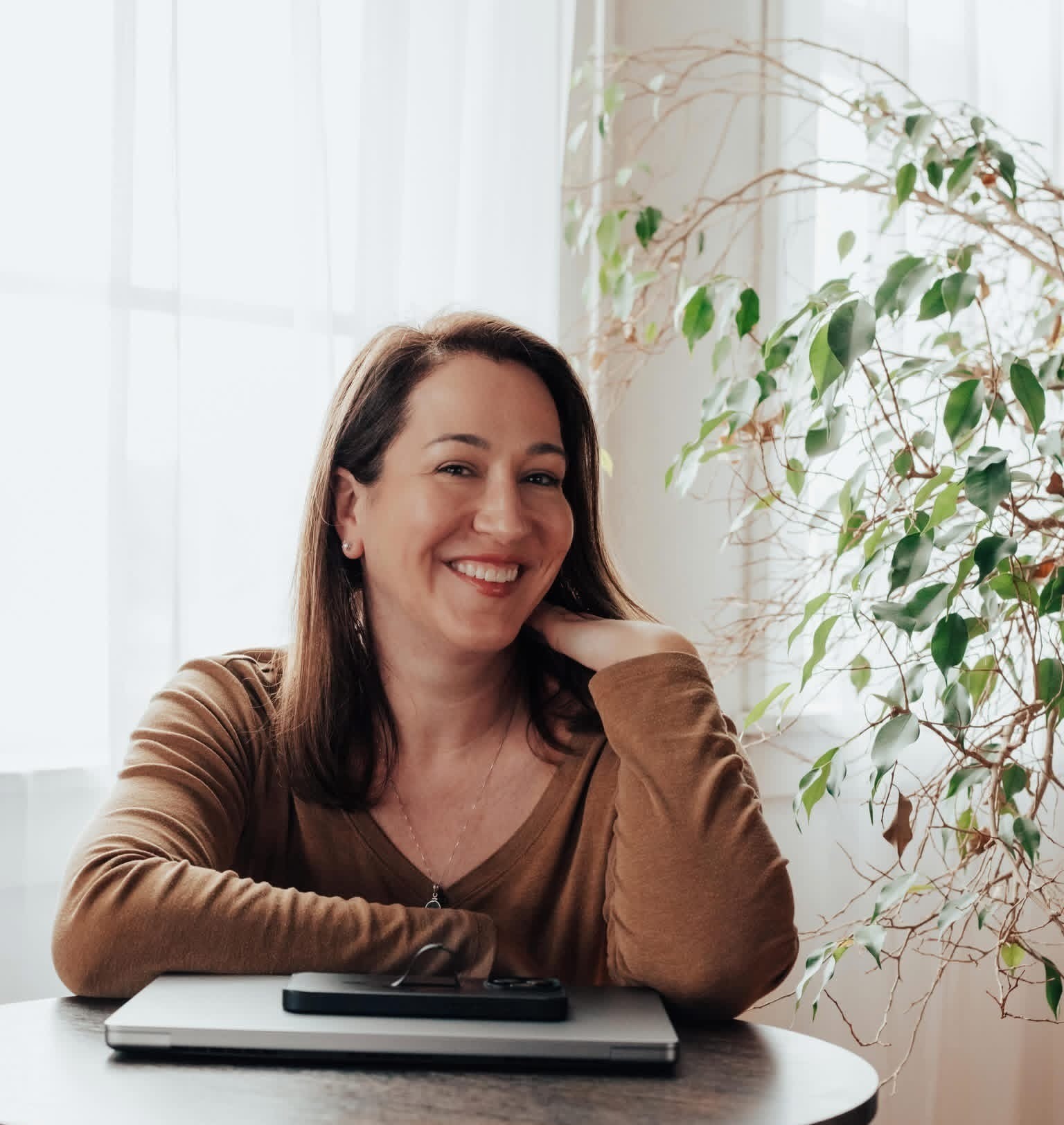Fractional CMO Katie Godbout sitting with closed laptop and phone